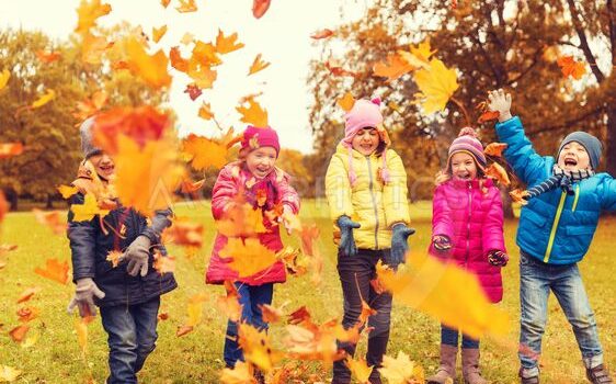 Kids playing in leaves outside