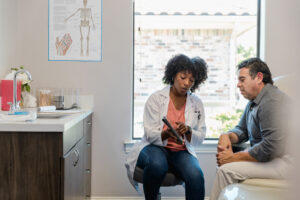 Young African American female doctor with male patient